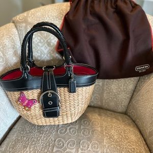 Authentic Coach purse made of straw over a structured frame with leather trim